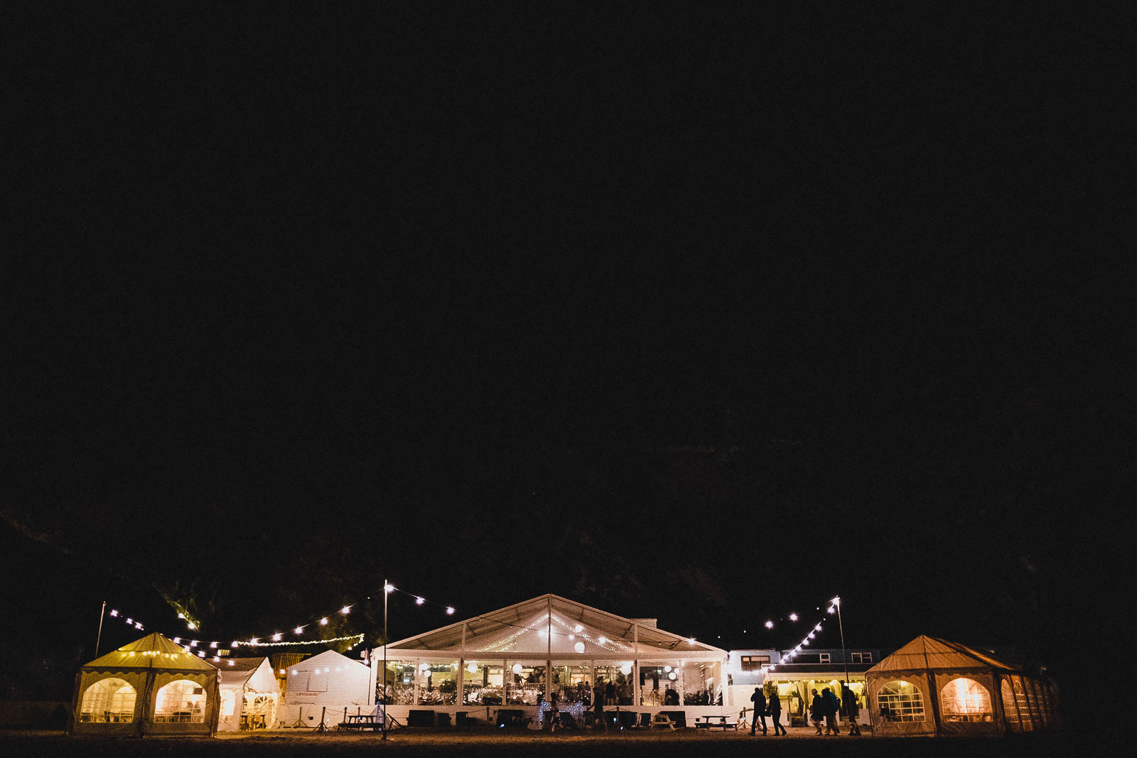 Lusty Glaze wedding venue at night, lit up by festoon lighting.